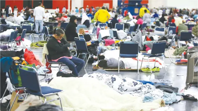  ??  ?? HOUSTON: People rest at the George R Brown Convention Center that has been set up as a shelter for evacuees escaping the floodwater­s from Tropical Storm Harvey in Houston yesterday.