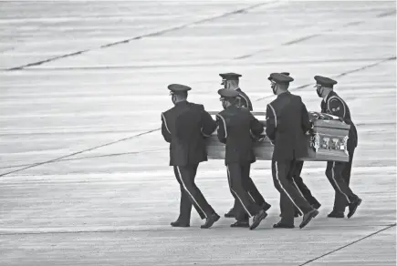  ?? ANGELA PETERSON / MILWAUKEE JOURNAL SENTINEL ?? The United States Air Force Honor Guard carries the remains of United States Air Force Airman 2nd Class Edward J. Miller at Milwaukee Mitchell Internatio­nal Airport on Friday. Miller had been missing in action for nearly 70 years after the Douglas C-124 Globemaste­r he was on board crashed into a remote mountain range, east of Anchorage, during a severe storm on Nov. 22, 1952. All 52 on board were lost.