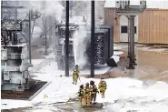  ?? AP PHOTO/STEVE APPS ?? Members of the Madison Fire department respond at the scene of a fire Friday at Madison Gas and Electric in Madison, Wis.