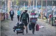  ??  ?? IT’S ALL OVER: Festival-goers leave the site at Glastonbur­y in Somerset yesterday after several days of music and culture.