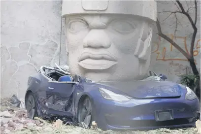  ?? Picture: AFP ?? IMPOSING. A replica of an Olmec head crushing a Tesla car in Mexico City. Sculptor Chavis Marmol says the work is addressing Mexico’s pre-Hispanic past from a Western neocolonia­l perspectiv­e.