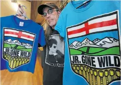  ?? ED KAISER/ EDMONTON JOURNAL ?? Jr. Gone Wild band member Mike McDonald shows the group’s T-shirt logos Thursday, which use Alberta’s coat of arms.