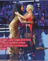  ??  ?? Singer Lady Gaga and host Tiffany Haddish share an intimate moment on stage.