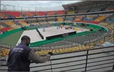  ?? AP PHOTO/SILVIA IZQUIERDO ?? A worker paints a fence at the Olympic Tennis Center inside Olympic Park in Rio de Janeiro, Brazil Feb. 4. The venue is one of four permanent arenas being run by the federal government, and was used for a one-day beach volleyball tournament.