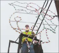  ??  ?? Stevie Waits looks through new ornament that he, Teddy Yarbrough and Williard Williams placed along Elm Street in Rockmart.