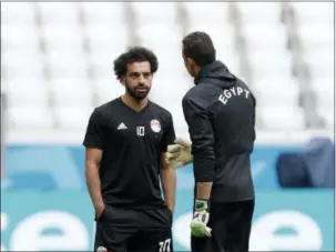  ?? DARKO VOJINOVIC — THE ASSOCIATED PRESS ?? Egypt’s Mohamed Salah, left, speaks with goalkeeper Essam El Hadary during Egypt’s official training on the eve of the group A match between Saudi Arabia and Egypt at the 2018 soccer World Cup in the Volgograd Arena, in Volgograd, Russia, Sunday.