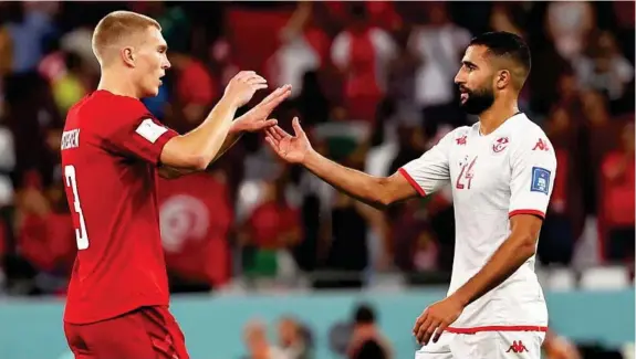  ?? EFE ?? El danés Rasmus Kristensen (25) y el tunecino Ali Abdi (28) se saludan al finalizar el partido disputado en el Education City Stadium de Doha.