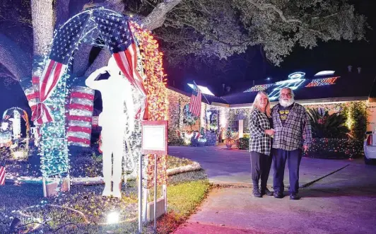  ?? Robin Jerstad / Contributo­r ?? Nancy and Rico Sardelli pose in front of their decorated home during the Windcrest Light Up event. The couple begins decorating their house each year in October.