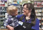  ??  ?? Kroger is offering employees like Erin, who was bagging groceries when she spotted a little boy who also has Down syndrome, $100 to get the COVID-19 vaccinatio­n.