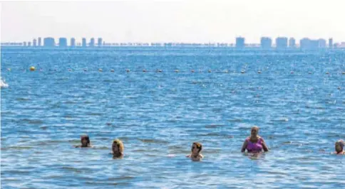  ?? // JUAN CARLOS SOLER ?? Un grupo de personas se baña en la playa Manzanares, el pasado jueves en Los Alcázares (Murcia)