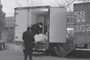  ?? AP PHOTO/DAKE KANG ?? Workers load body bags into a truck at a funeral complex in Beijing on Friday, December 16, 2022. Deaths linked to Covid are beginning to appear in China, even as those deaths are not reflected in the official tally. relatives of people who died in Beijing said their loved ones had tested positive for the coronaviru­s before their deaths, while employees at shops in one funeral complex said there has been a noticeable uptick in traffic in the past few days.