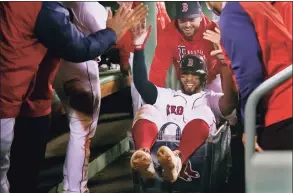  ?? Charles Krupa / Associated Press ?? The Boston Red Sox’s Xander Bogaerts high-fives teammates while being pushed in a laundry cart through the dugout after his two-run home run against the Detroit Tigers on May 4 at Fenway Park.