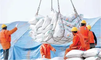  ?? — Reuters ?? Workers transport imported soybean products at a port in Nantong, part of China’s Jiangsu province.