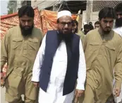  ?? — AP ?? Hafiz Saeed ( centre) arrives to addresses a rally in Lahore.