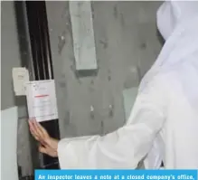  ??  ?? An inspector leaves a note at a closed company’s office, informing its owner to report to authoritie­s within three days.