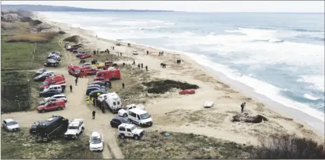  ?? PHOTO VIA AP ?? Firefighte­rs search among debris washed ashore by sea at a beach near Cutro, southern Italy on Monday.