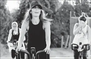  ?? STEVEN SENNE/AP ?? Jeanne Carter, co-owner of Fuel Training Studio, in Newburypor­t, Massachuse­tts, front, works out last month on a stationary bike.