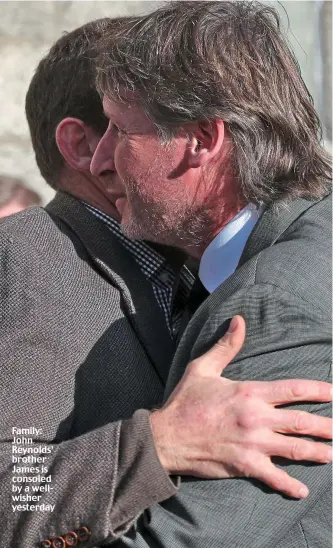  ??  ?? Family: John Reynolds’ brother James is consoled by a wellwisher yesterday