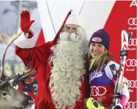  ??  ?? LEVI: First placed Mikaela Shiffrin poses with man dressed as Santa Claus on the podium of an alpine skiing women’s World Cup slalom, in Levi, Finland, yesterday. —AP