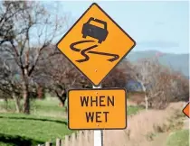  ??  ?? ‘Slippery when wet’ signs have been placed at 44 sites in Southland before the seal is repaired over summer.