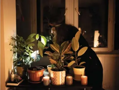  ?? © Serhii Korovayny/wsj ?? Daria Vilokova geeft de planten water. Noodgedwon­gen met een zaklamp en bij kaarslicht.