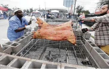  ?? Houston Chronicle file ?? Rodney Scott, left, of Scott’s Bar-B-Que in Hemingway, S.C., turns a whole hog at a pit during 2016’s Southern Smoke, a fundraiser for the National Multiple Sclerosis Society. Scott will take part again this year.