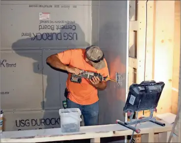  ?? Doug Walker / Rome News-Tribune ?? Michael Mantooth works on the electrical circuit in the wall of one of the food court units being developed on the first floor of the building at 114 Broad St. The second floor will house apartments.