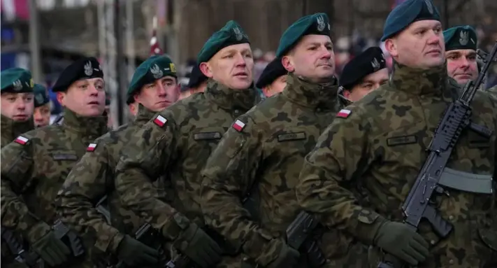  ?? ?? ► Oficiales del ejército polaco marchan durante un desfile para celebrar el aniversari­o de la independen­cia de Letonia.