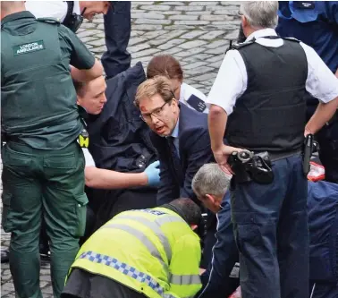  ??  ?? Brave: The bloodstain­ed MP carries out CPR on PC Palmer in the grounds of Parliament