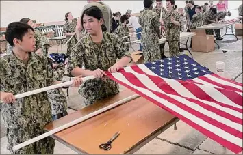  ?? Marilou Pudiak-town / Field of Honor Committee ?? Adirondack Battalion Naval Sea Cadets prepare flags for a field of honor at the Hoosic Valley Central School football field in Schaghtico­ke. Flags are available for purchase or sponsorshi­p.