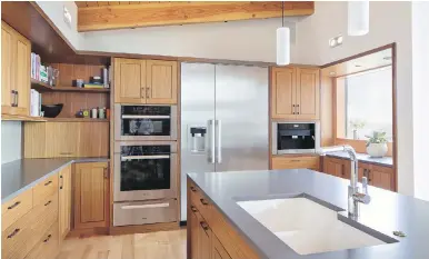  ?? PHOTOS BY STEVE RINGMAN, SEATTLE TIMES ?? The kitchen features Afrormosia (African teak) cabinetry and a ceramic backsplash.