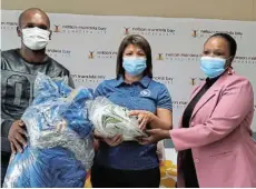  ?? Picture: VUYOKAZI NKANJENI ?? HELPING HAND: BD Blues Rugby Club manager Neville Nortje receives sporting equipment from Nelson Mandela Bay’s sport, recreation, arts and culture political head, Helga van Staaden, and councillor Bulelwa Jacobs