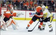  ?? TOM MIHALEK — THE ASSOCIATED PRESS ?? Pittsburgh Penguins’ Sidney Crosby, right, positions himself in front of the net and Philadelph­ia Flyers goalie Brian Elliott, left, and Ivan Provorov during the second period in Game 3 of an NHL first-round hockey playoff series Sunday in...