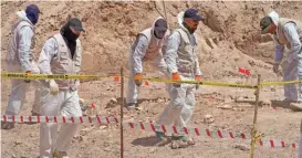  ?? (AfP) ?? Forensic experts working for the Iraqi authoritie­s in a mass grave near city of Najaf, on Saturday