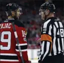  ?? Julio Cortez ?? The Associated Press file New Jersey Devils center Travis Zajac talks in March 2017 to referee Garrett Rank during an NHL game in Newark,
N.J. Rank, a full-time NHL referee, will play his first U.S. Open this week.