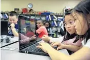 ?? JACOB LANGSTON/STAFF PHOTOGRAPH­ER ?? Altamonte Elementary 4th-graders Ruby Pham, right, and Tina Nguyen get in some coding work Monday during class.