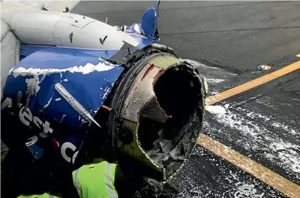  ?? PHOTO: AP ?? National Transporta­tion Safety Board investigat­ors examine damage to the engine of the Southwest Airlines plane that made an emergency landing in Philadelph­ia after the engine failed and debris smashed a window. A woman passenger was almost sucked out...