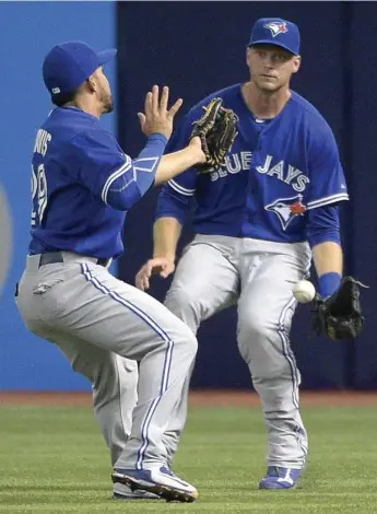  ?? PHELAN M. EBENHACK/THE ASSOCIATED PRESS ?? Jays’ Devon Travis, left, and Michael Saunders look on as a Tampa Bay double falls between them in play Sunday.