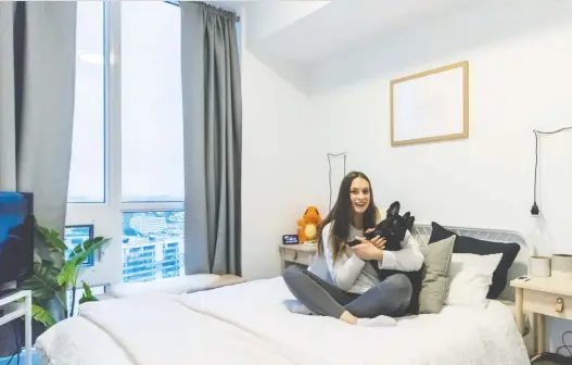  ??  ?? Swimmer Penny Oleksiak with her French bulldog Norman in her bedroom, where she chills after her long days of practice.