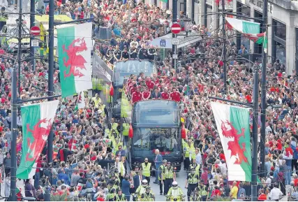  ?? Stu Forster ?? > Thousands lined the streets of the capital to welcome the Wales football squad on their bus parade as part of their Euro 2016 homecoming tour in July last year. Inset, Osian Roberts