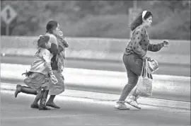  ?? Don Bartletti Los Angeles Times ?? WOMEN AND CHILDREN sprint across lanes of the 5 Freeway just north of the border in July 1990. Illegal entries into the U.S. have plunged in recent years.