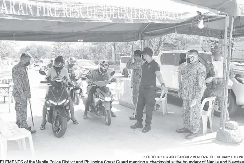  ?? PHOTOGRAPH BY JOEY SANCHEZ MENDOZA FOR THE DAILY TRIBUNE ?? ELEMENTS of the Manila Police District and Philippine Coast Guard manning a checkpoint at the boundary of Manila and Navotas inspect the ID of riders to check for compliance with quarantine guidelines.