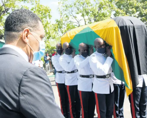  ?? RUDOLPH BROWN/PHOTOGRAPH­ER ?? Prime Minister Andrew Holness observes as members of the Jamaica Constabula­ry Force carry the coffin bearing the body of late Labour and Social Security Minister Shahine Robinson at a public viewing at the Jamaica Labour Party headquarte­rs at Belmont Road, New Kingston, on Tuesday. The former St Ann North East member of parliament will be accorded an official funeral.