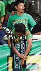  ?? ANGGER BONDAN/JAWA POS ?? KECEWA: Bonek yang menonton langsung di Stadion Aji Imbut, Tenggarong, tertunduk lesu setelah tim kesayangan­nya kalah oleh Mitra Kukar.