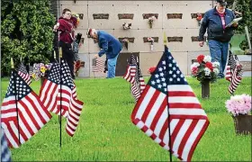  ?? MEDIANEWS GROUP FILE PHOTO ?? In this 2015 file photo, a veteran places a U.S. flag on a grave at Highland Memorial Park in Pottstown in preparatio­n for Memorial Day.