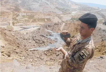  ?? MOHAMMED ZAATARI/AP ?? Israeli airstrikes: A Lebanese soldier displays part of an Israeli missile from an airstrike in Dimashqiya farmlands in southern Lebanon. Israel on Thursday escalated its response to rocket attacks this week by launching airstrikes overnight on Lebanon. A statement from the Israeli military said jets struck the launch sites from which the rockets were fired.