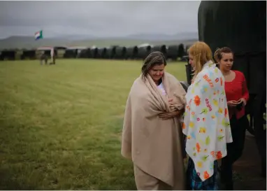  ?? PICTURE: EPA ?? SHOWING PRIDE: An Afrikaner woman, left, holding her baby as she stands in the middle of the ox wagon monument during a Boer War memorial held at the site of the Battle of Blood River near Dundee on December 16, 2014.