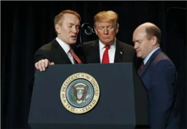  ?? EVAN VUCCI — THE ASSOCIATED PRESS ?? Rep. James Lankford, R-Okla., left, President Donald Trump, center, and Sen. Chris Coons, D-Del., pray during the National Prayer Breakfast, Thursday in Washington.