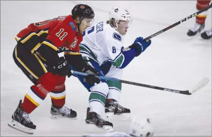  ?? The Canadian Press ?? Vancouver Canucks winger Brock Boeser, right, and Calgary Flames centre Mikael Backlund, chase the puck during preseason NHL action in Calgary on Sept. 22. They face-off for real tonight as Vancouver hosts Calgary to open the regular season. Game time is 7 p.m. PT.