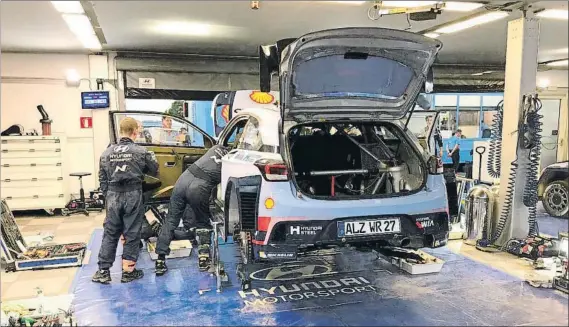  ?? FOTO: A. SAN ANDRÉS ?? Los mecánicos de Hyundai, antes de montar la especifica­ciones de asfalto del coche de Dani Sordo ayer en la asistencia del equipo del piloto español en el RallyRACC Catalunya